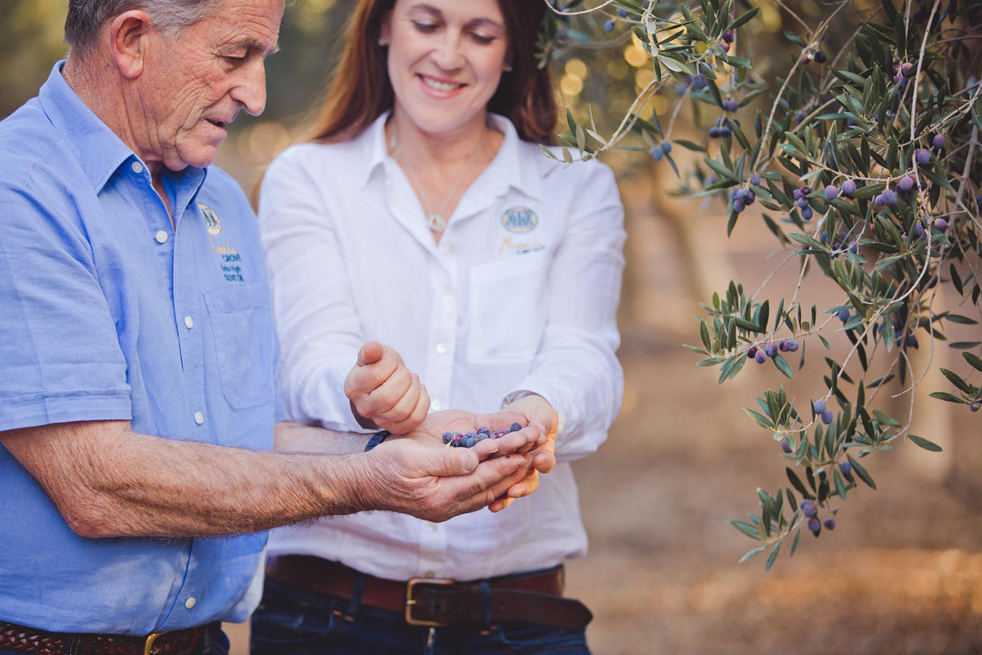 Natasha and Frank DalBon stood in the olive grove holding olives in their hands