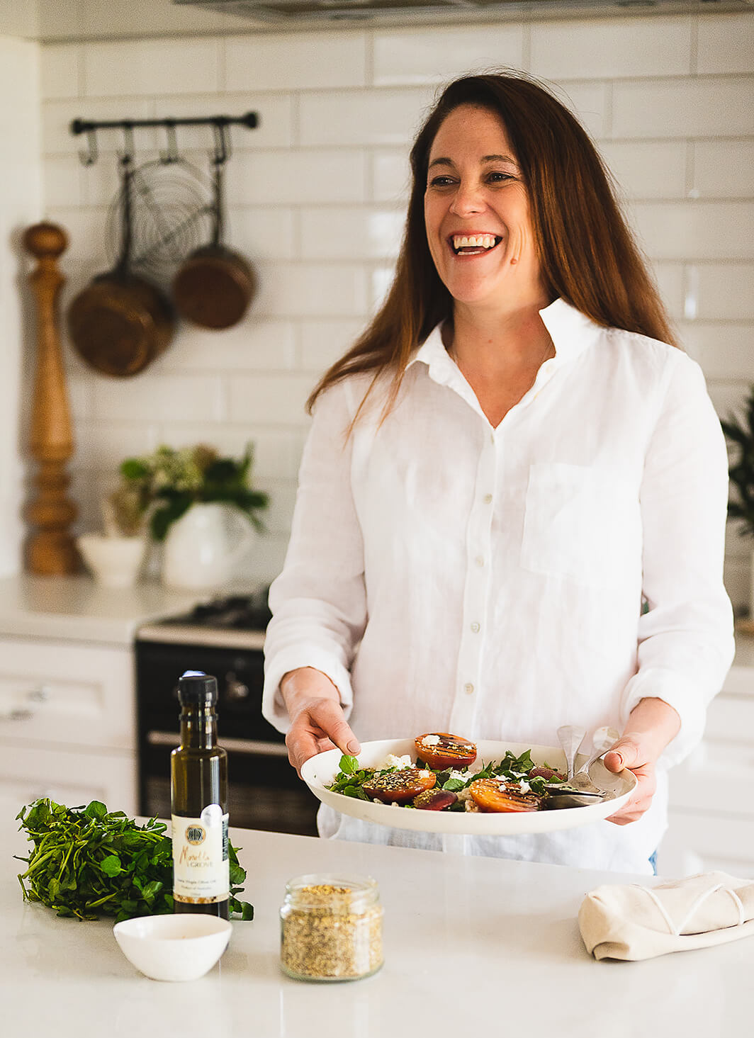 Natasha DalBon in the kitchen plating up a salad
