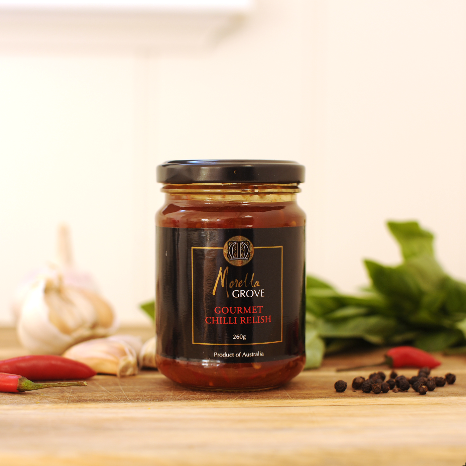 Morella Grove gourmet chilli relish jar on a table with chilis